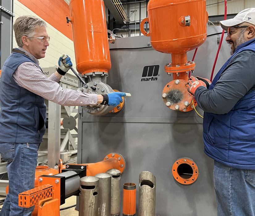 L-R: Martin Engineering business development manager Mike Masterson and product manager Sid Dev working at the air cannon test stand at the company’s Center for Innovation