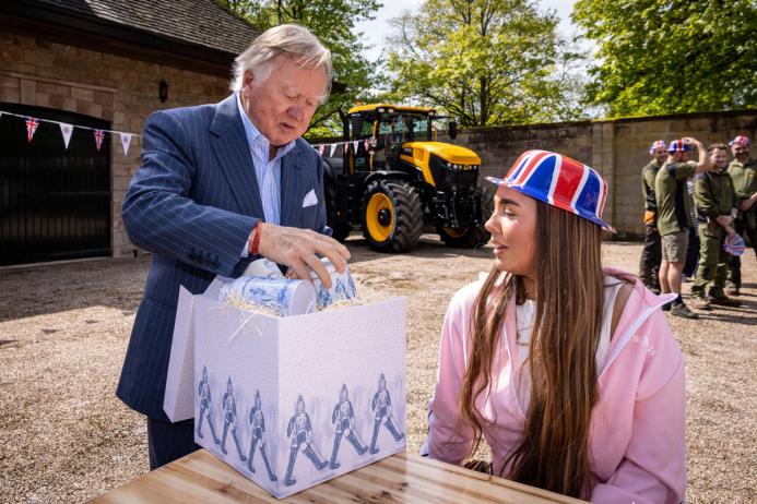 Lord Bamford presents one of the first Coronation gifts to employee Kimberley Brandrick during one of the special celebration lunches