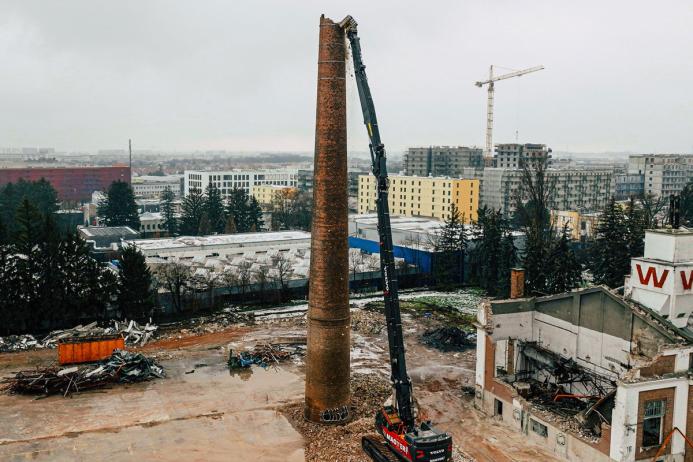 Volvo EC750E high-reach demolition excavator bringing down a 38m high chimney