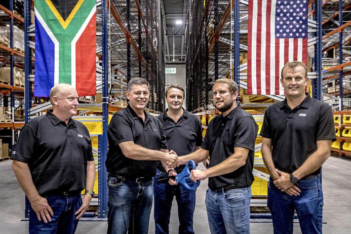 Bell Equipment group chief executive Leon Goosen (second from left) is handed the ceremonial scissors by ALC general manager Andrew Pretorius, while Bell directors, Stephen Jones, Aldo Mayer and Meltus Badenhorst look on