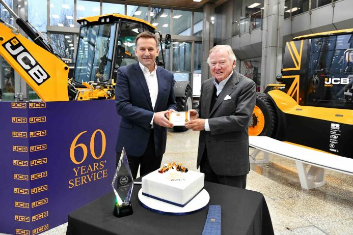 Anthony Bamford (right) receives his 60 year long service award from JCB CEO Graeme Macdonald.