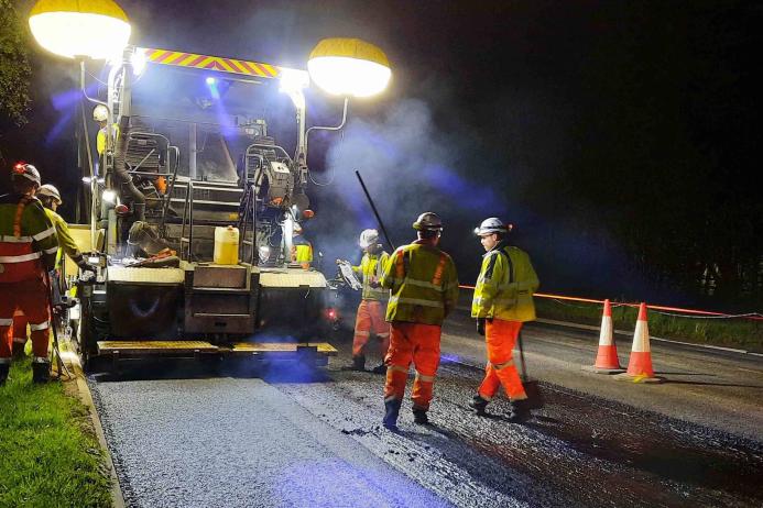Paving machine laying asphalt containing hydrated lime on the A38 in Devon