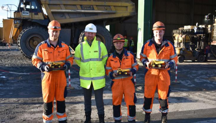 L-R: Owen Carr, Max Anderson and Jake Adkins receiving commemorative model dumptrucks to mark the completion of their apprenticeships from Robbie Bentham (yellow jacket), plant director at Banks Mining Banks Mining apprentices