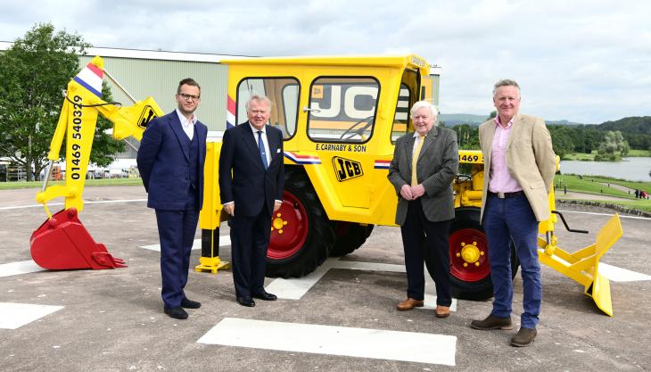 L-R: George Bamford, Lord Bamford, Roland Carnaby Senior and Roland Carnaby Junior, pictured with the newly restored machine Carnaby machine