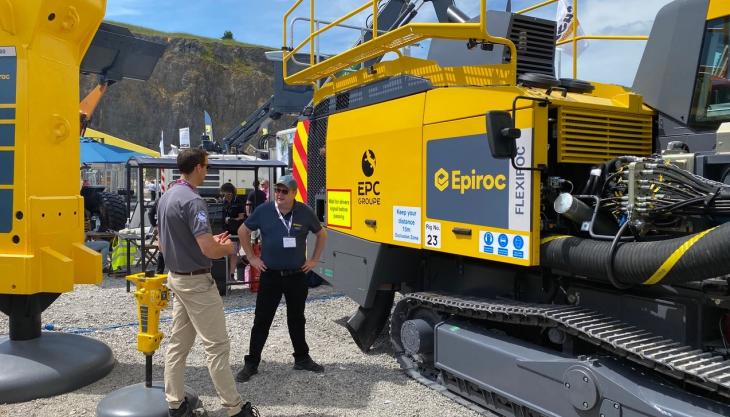 Ben Coppock, general manager of blasting and explosives at EPC-UK (left), and Jason Reilly, area sales manager at Epiroc (right), next to the FlexiROC D55 rig EPC-UK and Epiroc