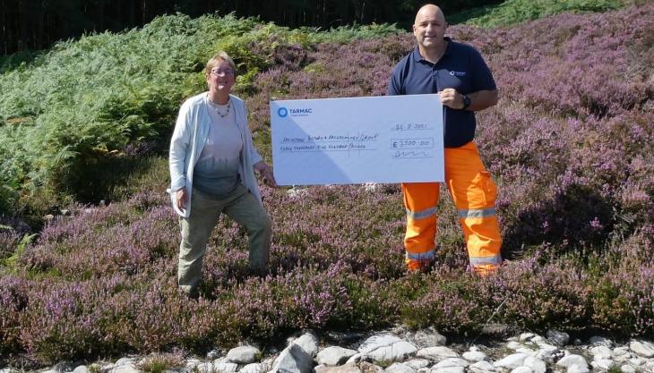 Jan Frazer, secretary of the Holystone History & Archaeology Group, receiving the donation from Harden Quarry manager Gareth Williams Harden donation