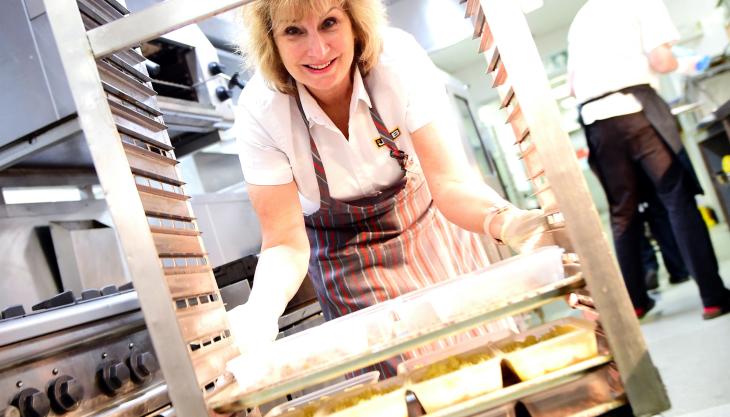 JCB's Jane Bullock helps prepare cottage pies ready for delivery to the city council JCB food aid