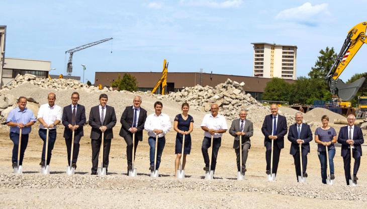 Liebherr-Hydraulikbagger GmbH managers, construction company staff and members of the local community break the ground together Liebherr ground-breaking ceremony