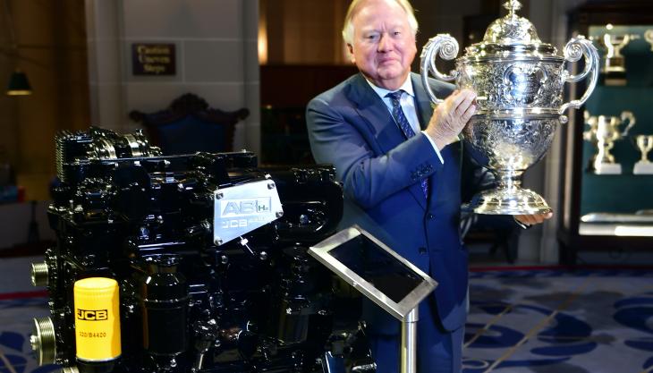 Lord Bamford with the Dewar Trophy and the award-winning hydrogen engine Lord Bamford