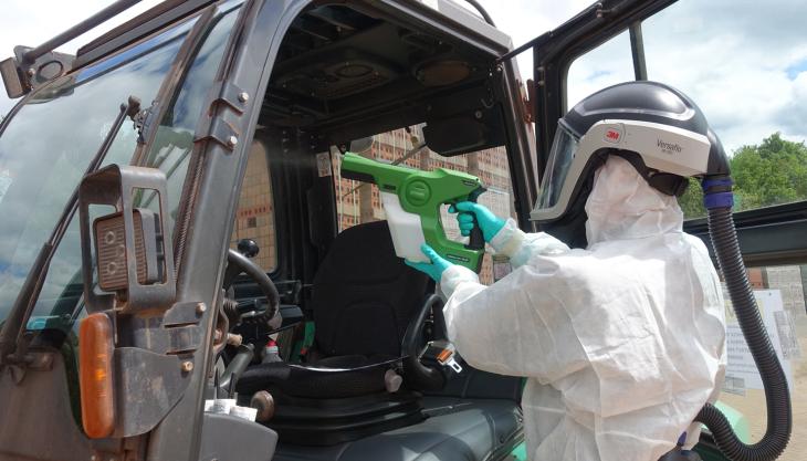 A decontamination technician from SafeGroup giving the interior of a material handler long-term protection against COVID-19 SafeGroup