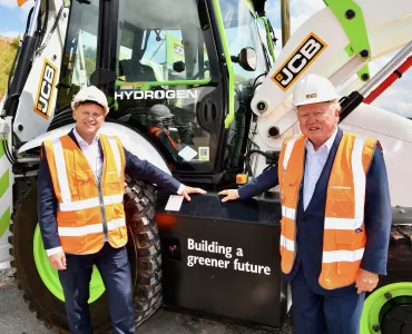 L-R: Energy Secretary Grant Shapps with JCB chairman Lord Bamford and the JCB hydrogen backhoe loader