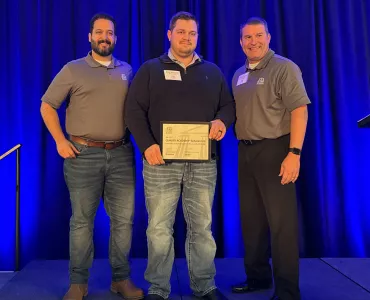 Evan McCorkle (centre) receiving his scholarship from Raphael Carmona (left) and Greg Tranor (right)