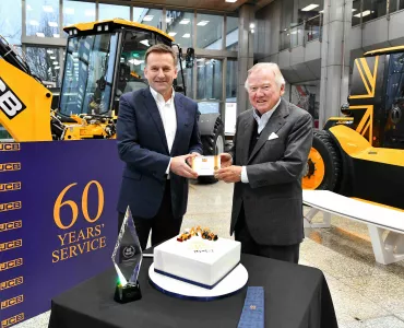 Anthony Bamford (right) receives his 60 year long service award from JCB CEO Graeme Macdonald.