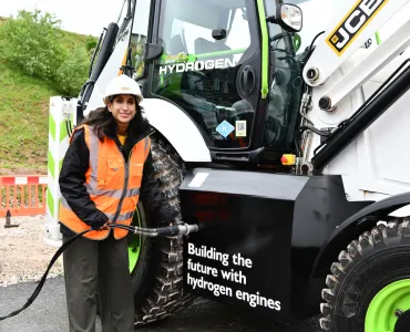 The Secretary of State for Energy Security and Net Zero, Claire Coutinho MP, tries her hand at the quick and easy task of refuelling a JCB backhoe loader with hydrogen