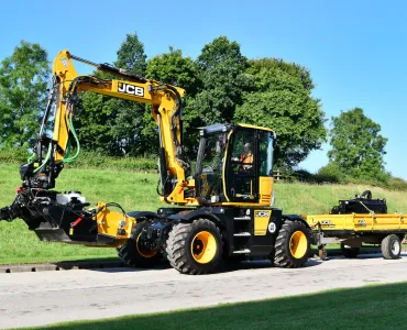 A JCB Pothole Pro wheeled excavator with purpose-built trailer