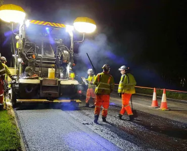 Paving machine laying asphalt containing hydrated lime on the A38 in Devon