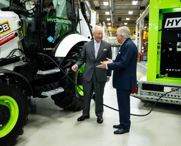 Lord Bamford explains to His Majesty The King the simple and quick process of refuelling a hydrogen backhoe loader