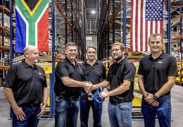 Bell Equipment group chief executive Leon Goosen (second from left) is handed the ceremonial scissors by ALC general manager Andrew Pretorius, while Bell directors, Stephen Jones, Aldo Mayer and Meltus Badenhorst look on