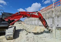 Excavator-mounted Kemroc KR 120 rotary drum cutter profiling the shoring wall before lining it with steel mesh and shotcrete 