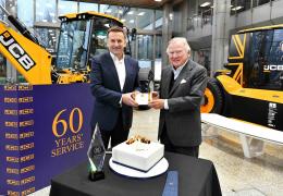 Anthony Bamford (right) receives his 60 year long service award from JCB CEO Graeme Macdonald.