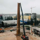 Volvo EC750E high-reach demolition excavator bringing down a 38m high chimney