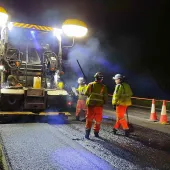 Paving machine laying asphalt containing hydrated lime on the A38 in Devon