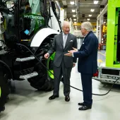 Lord Bamford explains to His Majesty The King the simple and quick process of refuelling a hydrogen backhoe loader